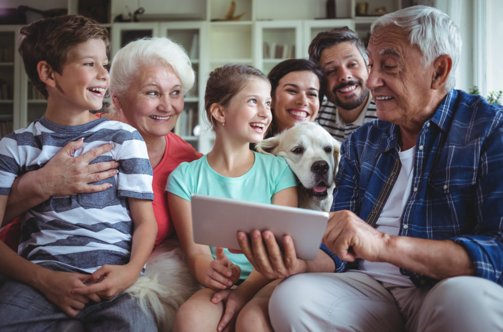 Famille multi-générations regardant joyeusement une tablette